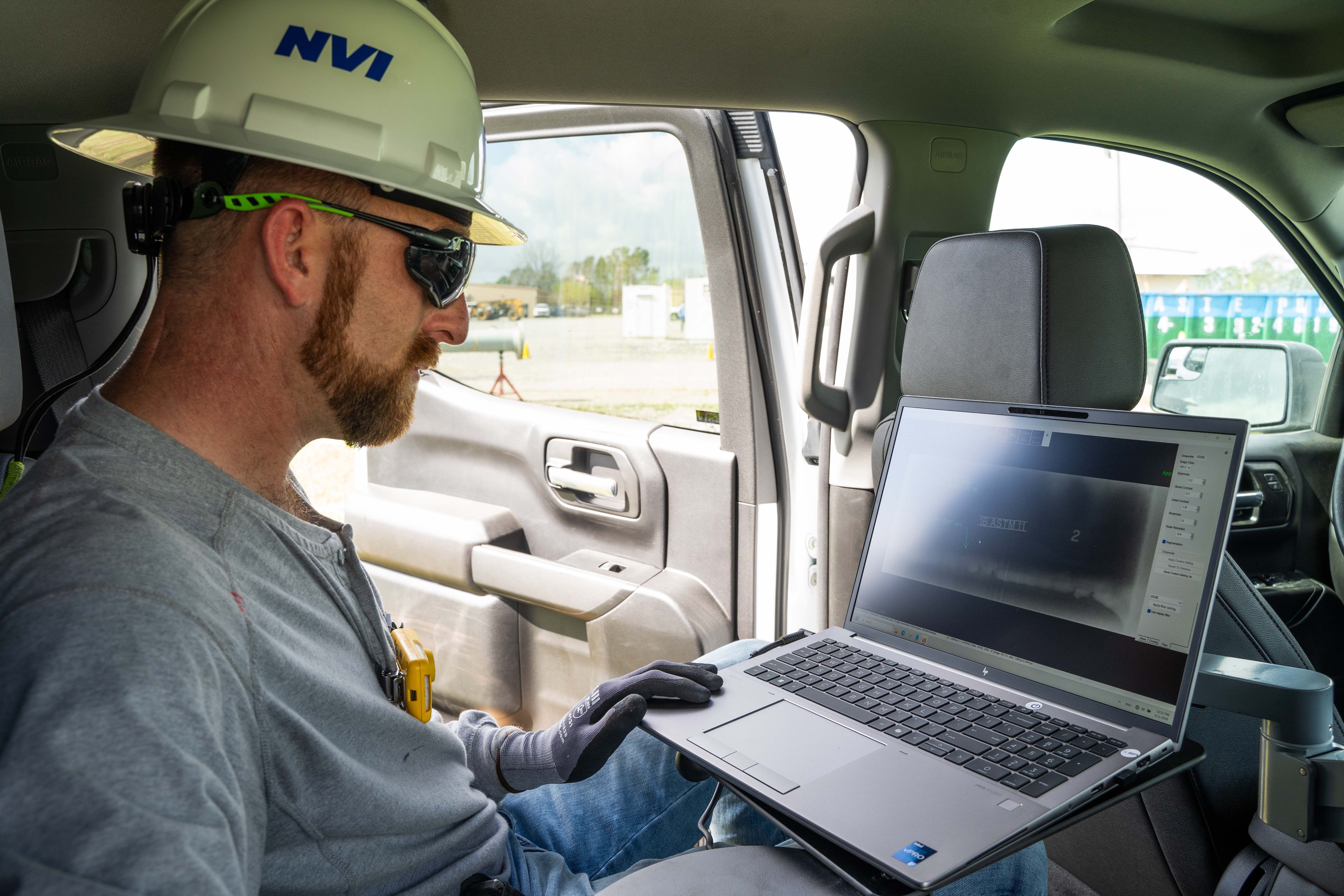 NVI technician reviewing CR scan on laptop in truck