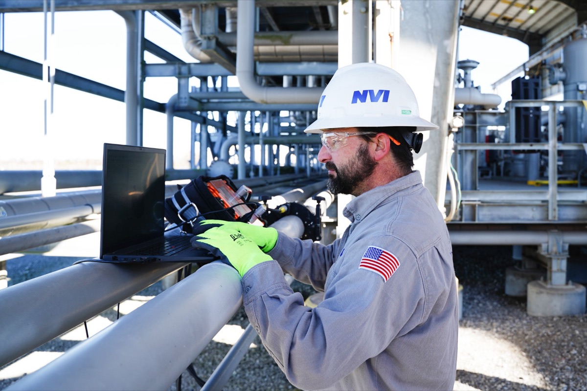 NVI technician inspecting process piping at a plant